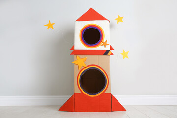 Cute handmade cardboard spaceship near light wall © New Africa