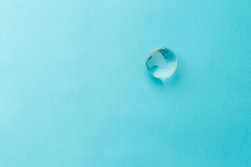 Glass globe on a light blue background. Nature concept for environment and conservation. Top view. Copy space. Flat lay