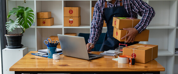 Starting small businesses SME owners man entrepreneurs working, box and check online orders to prepare to pack the boxes, sell to customers, sme business ideas online.