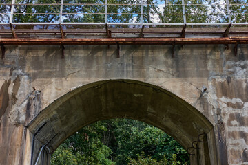 Fototapeta na wymiar Concrete arched vault, passage under the railway towards the forest.