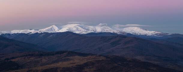 Fototapeta na wymiar Far away - snowy mountains at sunset