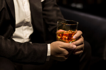 Closeup businessmen holding a glass of whiskey