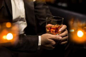 Closeup businessmen holding a glass of whiskey