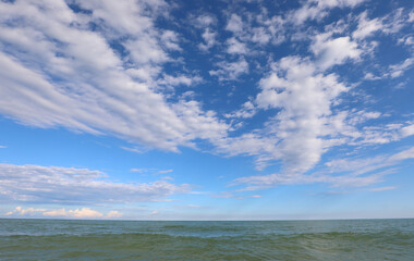 white clouds and the sea below feels people ideal as a backdrop for overlaying photographs or as a theme to tranquility