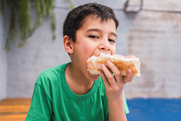 Hungry boy eating hot dog