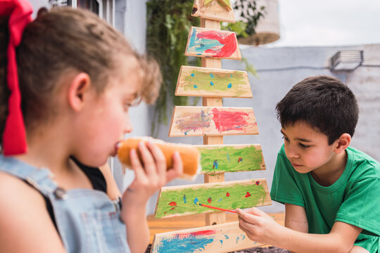 Children with food painting wooden Christmas tree