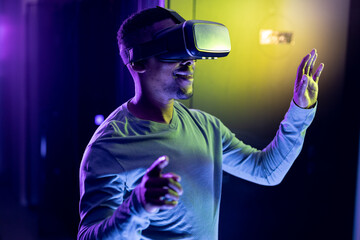 African american male computer technician wearing vr headset and working in server room