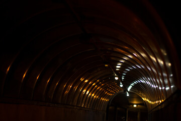 Light on the plastic surface of the tunnel. Night lights on the sparkling dome.