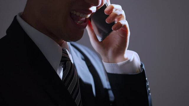 スマホで電話する中年ビジネスマン（ビジネスイメージ）