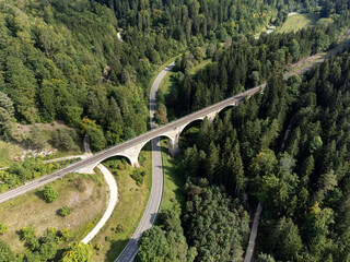 Eisenbahnviadukt, Landstraße und Forststraße führen durch einen Wald
