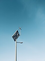 Street lamp on the blue sky, wind turbine and solar panel