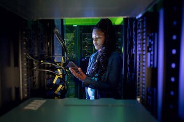 African american female computer technician using tablet and working in server room