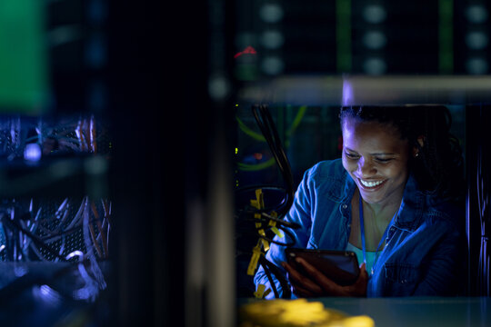 African american female computer technician using tablet and working in server room