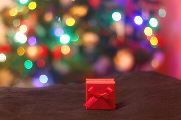 Small red Christmas present under the Christmas tree. Selective focus.