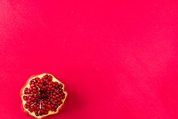 An open pomegranate on a pink background. Space for text. top view