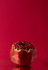 An open pomegranate on a pink background. Space for text. top view