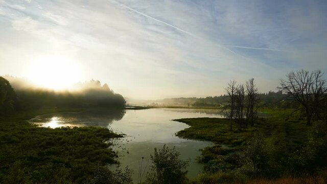 Time Lapse UHD movie of low clouds and fog rolling over wetlands in Salmon Creek Greenway at sunrise one early morning during Fall Season USA America Ultra High Definition 4k 