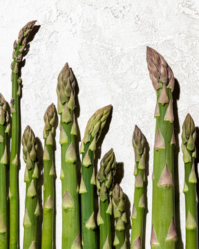 A closeup shot of asparagus spears shot on a light background in direct light