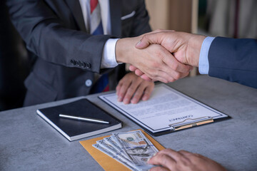 Businessmen or politicians agree to accept bribes. by shaking hands To do illegal business, corruption in the contracting business, corruption concept and bribery.