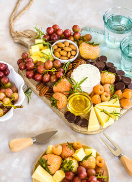 Cheese board with cheese, nuts, fruits, berries and chocolate