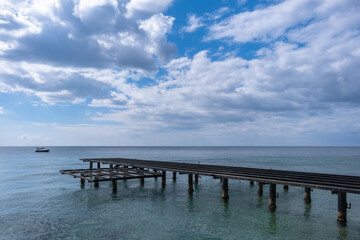 Fototapeta na wymiar Old and rusty metal pier on the seashore.