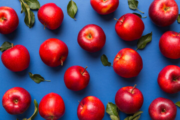 Many red apples on colored background, top view. Autumn pattern with fresh apple above view