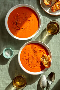 Two bowls of roasted tomato soup on the table