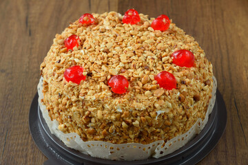 Delicious cake with peanut and cherry ontop.