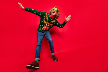 Photo of charming cute young guy dressed print pullover glasses smiling dancing empty space isolated red color background