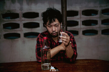 Asian man drink vodka alone at home on night time,Thailand people,Stress man drunk concept