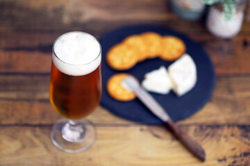 グラスに注がれたビールとカマンベールチーズとクラッカー