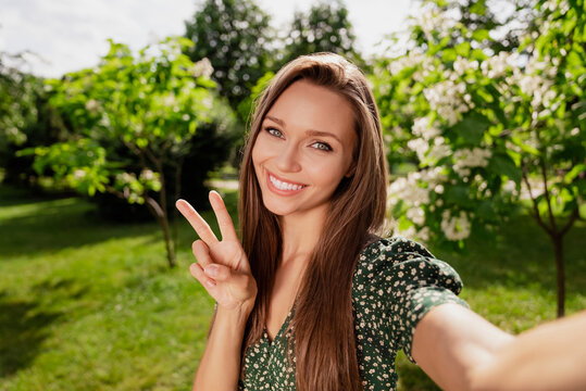 Photo of friendly blogger charming lady take selfie show v-sign wear green dress nature park garden outdoors