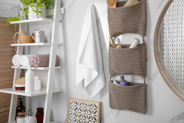Knitted organizer hanging on wall in bathroom
