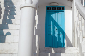 Traditional Greek blue doors in white bulding with white stairs