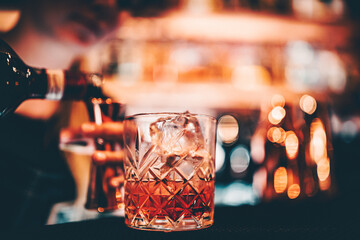 woman bartender hand making negroni cocktail. Negroni classic cocktail and gin short drink with sweet vermouth, red bitter liqueur
