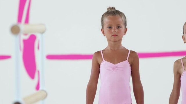 Two little girls gymnasts walking to a handrail and proudly looking in the camera