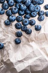 Organic, ripe blueberries on the brown craft paper, close up, copy space. Healthy snack, food background.