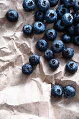 Organic, ripe blueberries on the brown craft paper, close up, copy space. Healthy snack, food background.