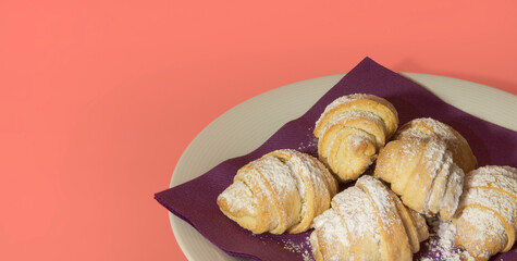 Sweet rolls on a purple napkin. Pink background. Copy space