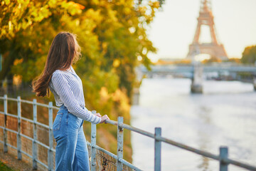 Beautiful young woman enjoying bright autumn day in Paris, France