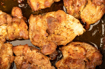 Fried pieces of meat in a frying pan, close-up, selective focus.