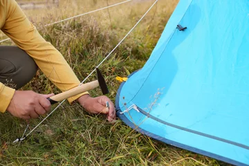 Fotobehang Man setting up camping tent outdoors, closeup © New Africa