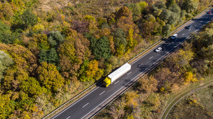 Aerial. Truck logistics aerial. Traffic motion by the countryside highway. View above from drone.