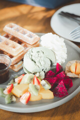 Close up on waffle with many of fruit and ice cream green tea