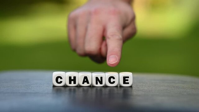 Hand is turning a dice and changes the word chance to change.