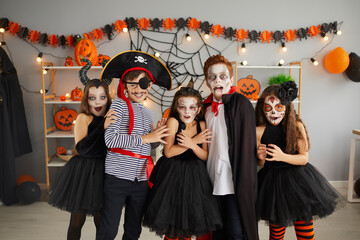 Portrait of group of children in creative costumes with scared faces at Halloween party. Little...