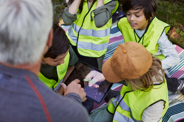 Teacher with school children using digital tablet