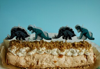 Meringue roll with whipped cream and dinosaur candles