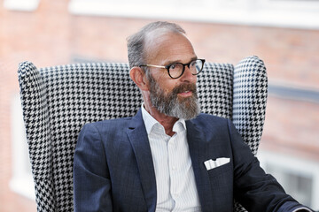 Businessman in armchair looking away