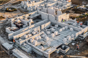 Building site Aerial view. construction site. workers in uniform and safety equipment have job on building. Installing brick wall.